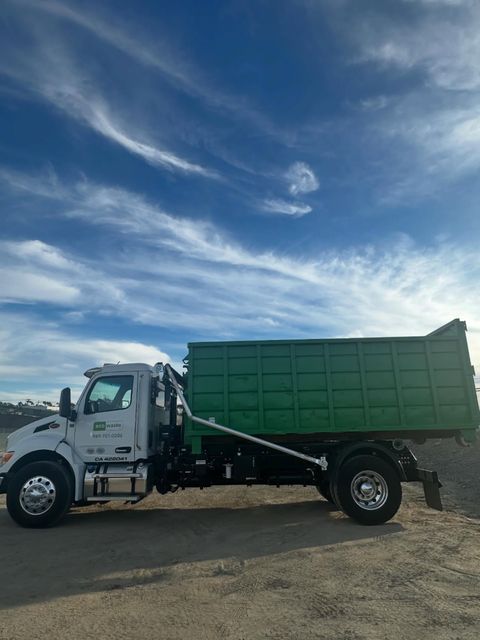 Eco Waste hooklift truck carrying a green roll-off bin